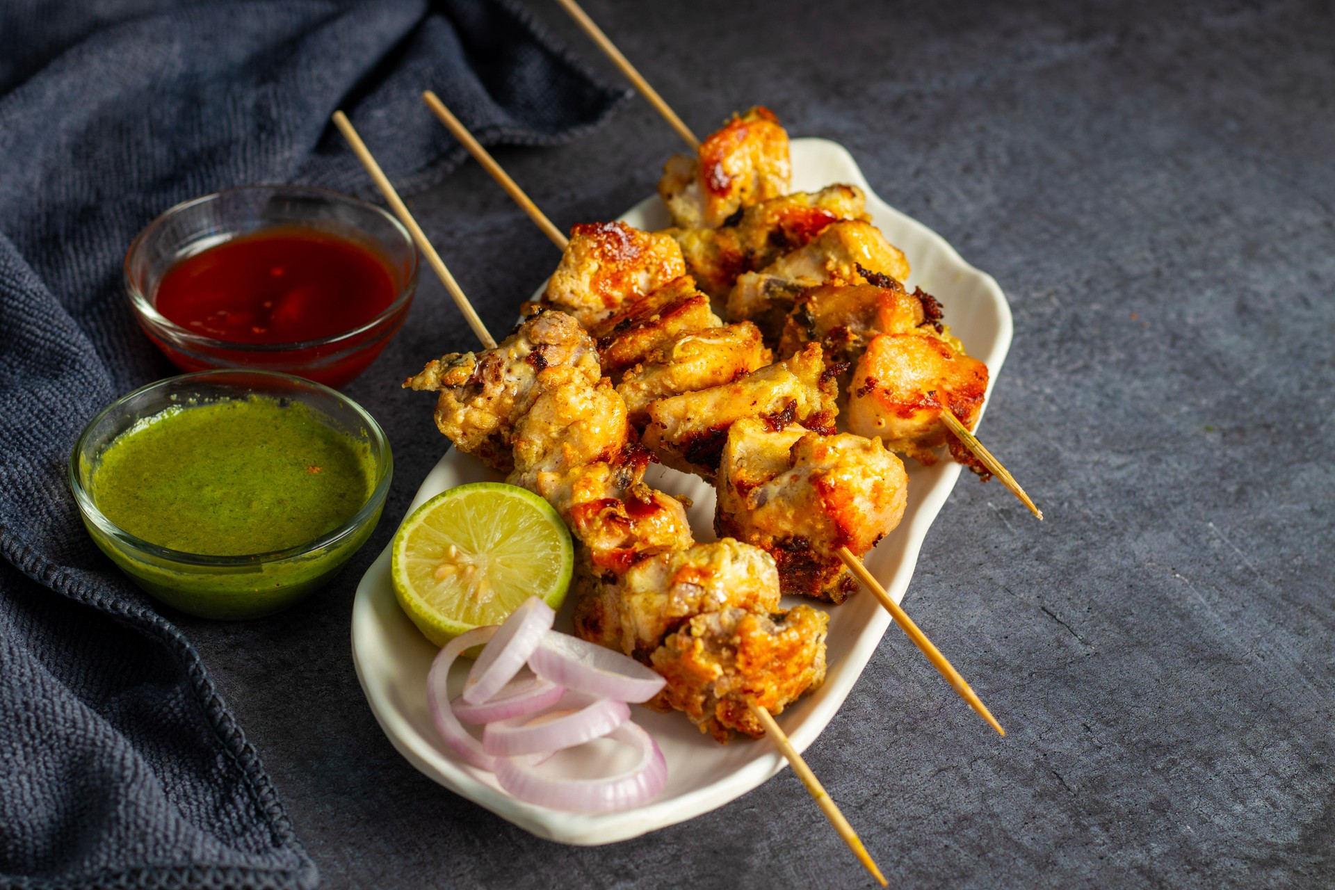 Chicken reshmi kabab or chicken malai kabab, delicious Mughlai cuisine, serve with mint chutney and tomato sauce. selective focus.