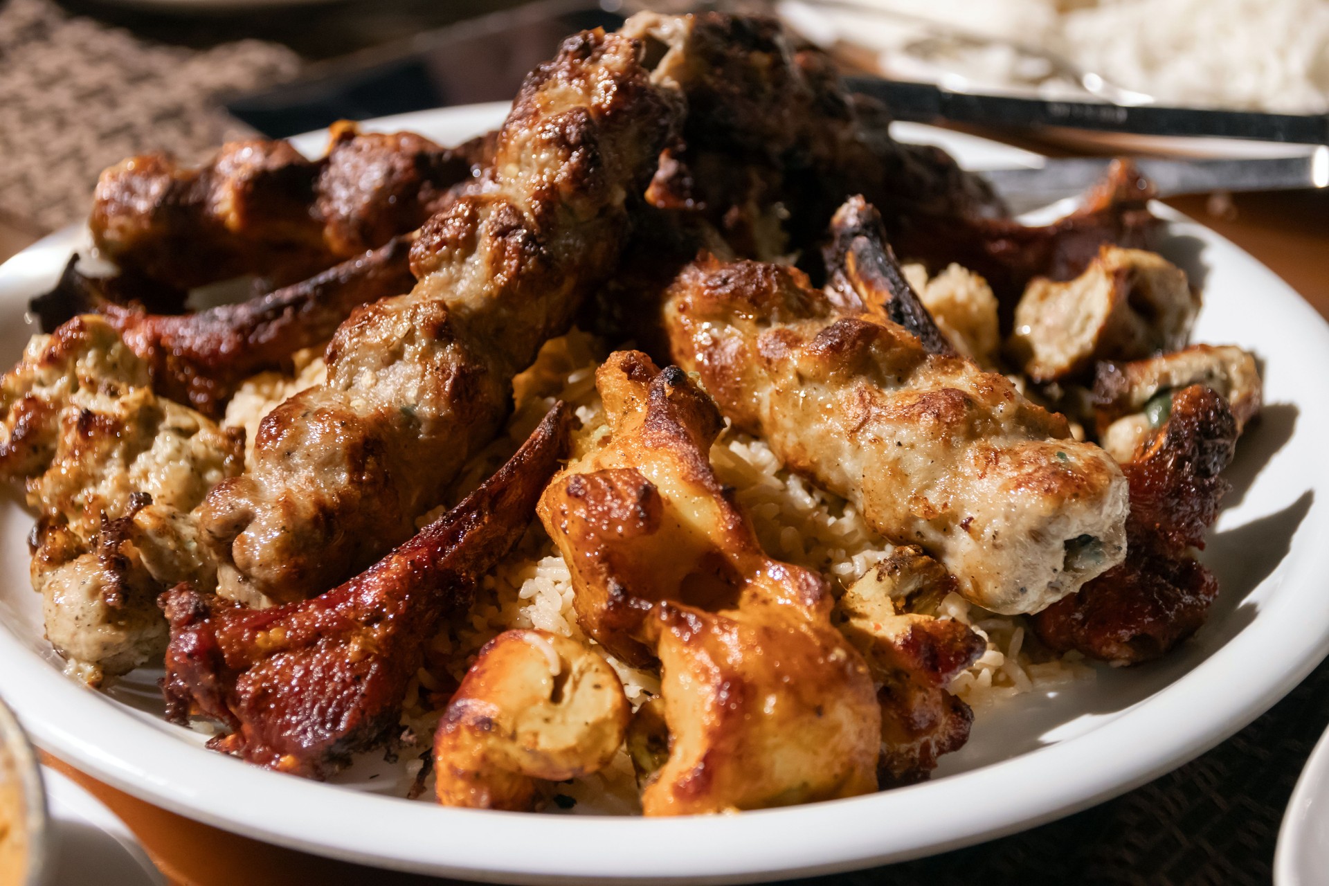 Biryani is a mixed rice dish, mainly popular in South Asia. A choice of meat (chicken, goat, lamb, beef) and lots of seasonings and spices. Delicious platter of grilled meat and rice.